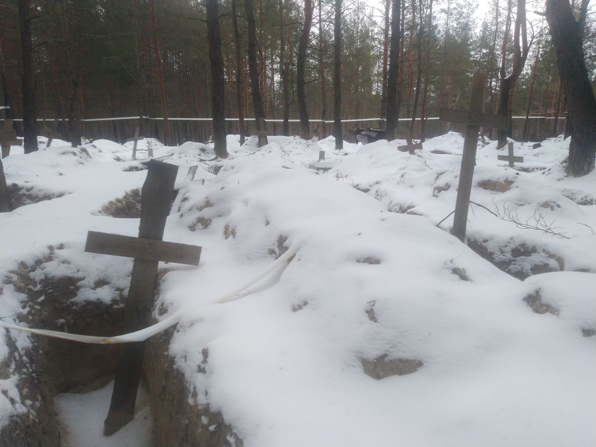 Pozůstatky provizorního pohřebiště obětí hromadných vražd civilistů z&nbsp;doby ruské okupace v&nbsp;roce 2022, Izjum, Charkovská oblast. Foto: Jan Šír